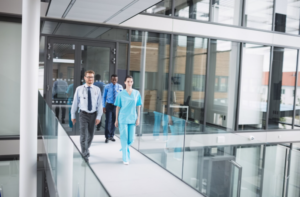 Doctors and nurses walking through hospital corridor with smart access control system in healthcare facility