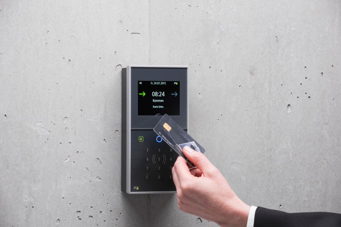 Employee swiping access card at office door reader system