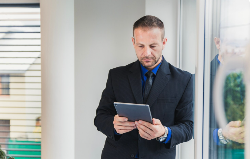 manager holding a tablet to check access control dashboard showing integration of mobile, biometric, and smart card systems